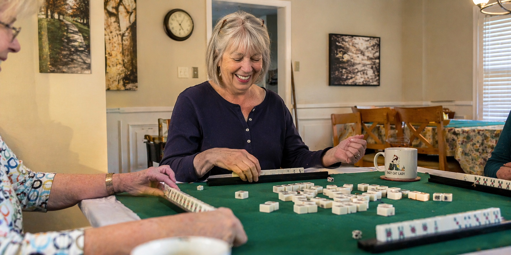 Confident woman at a Mah Jongg table, playing decisively
